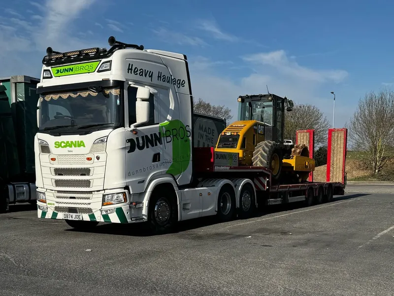 Dunn Bros Scania lorry carrying a CAT roller on a low-loader