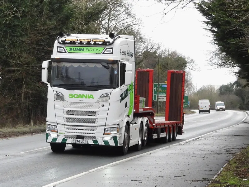 Dunn Bros Scania heavy haulage lorry with a low-loader trailer on the road